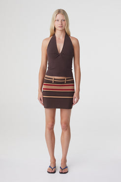 Thea Twist Top in Espresso with a striped mini skirt, front view showing the fitted silhouette and halter neckline.