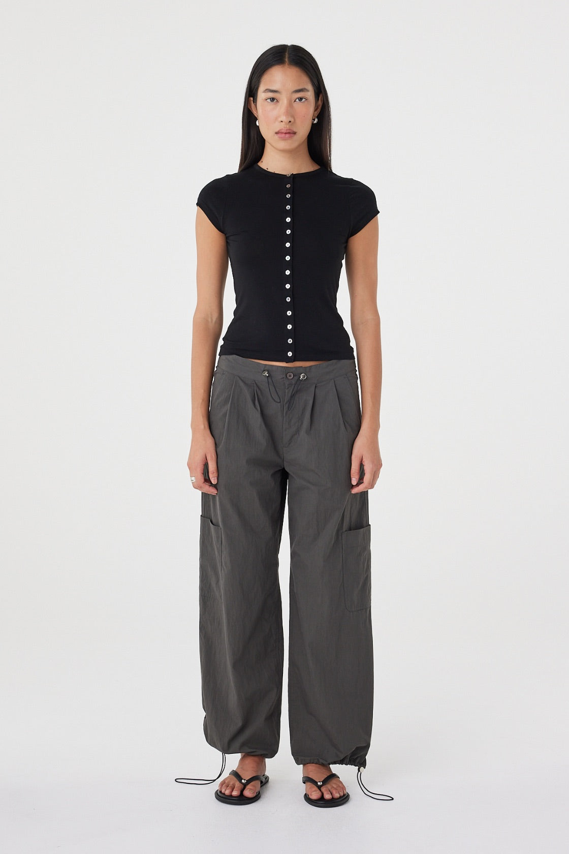 Front view of the Robbie Top in Black highlighting the smooth fine knit, button front detailing and close-fitting silhouette.