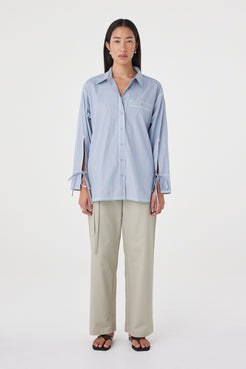 Full-length front view of the Blair Shirt in Blue Taupe Stripe highlighting the relaxed silhouette, oversized cuffs with tie detail and contrast overlocking.