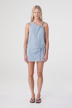 Clara Mini Dress in Dusk Blue, full front view highlighting the asymmetrical neckline, clear bead shoulder detail and low waist tie.