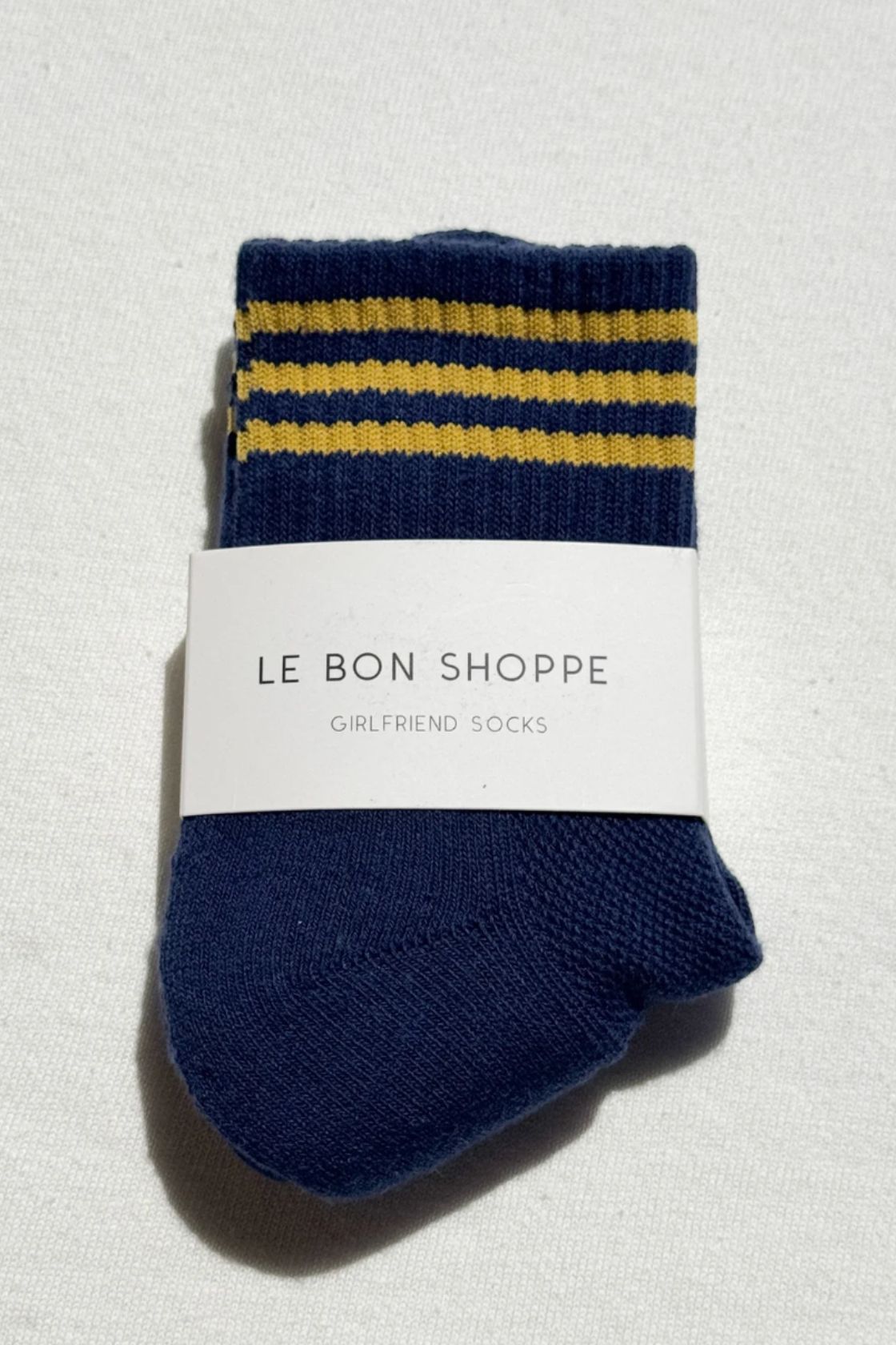 Navy socks with yellow stripe cuff folded with Le Bon Shoppe label