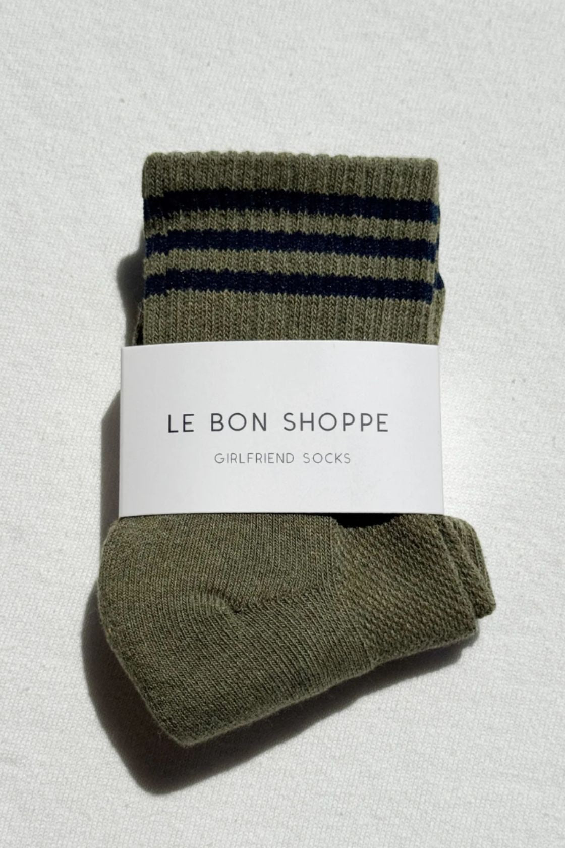 Sage green socks with dark stripe cuff folded with Le Bon Shoppe label