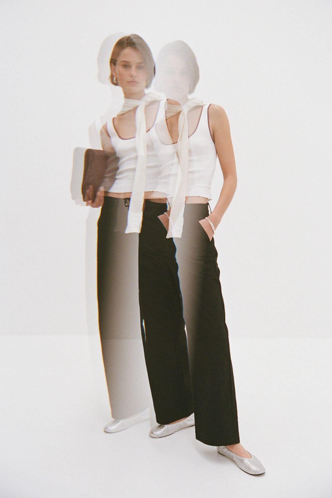 White cropped tank and black tailored trousers with layered scarf detail, minimalist elevated basics