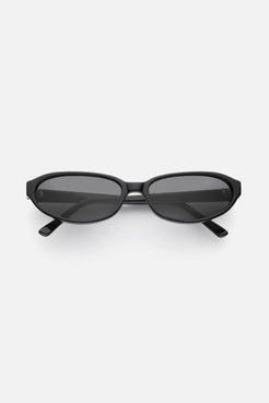 Black oval-frame sunglasses in glossy acetate, with sculpted arms and dark lenses for minimalist everyday styling.