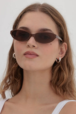 Side profile of cinnamon sunglasses worn with clean makeup and white tank, ideal for late summer to early autumn transitions.
