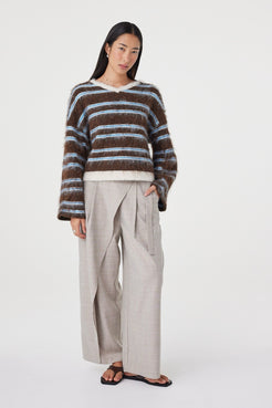 Angled view of the Lucca Sweater in Espresso & Blue Stripe showcasing the fluffy knit texture, relaxed drape and soft contrast stripe pattern, styled with taupe wide-leg trousers.