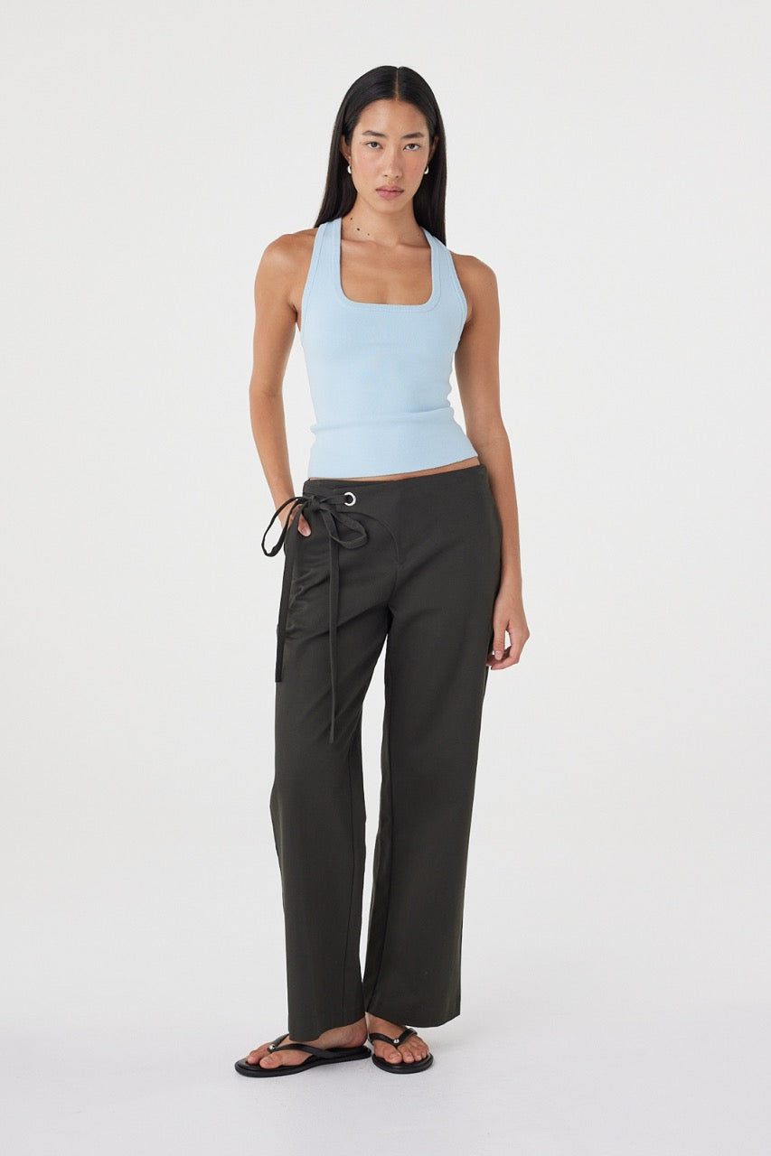 Full-length view of the Lucia Tie Pant in Charcoal styled with a pale blue fitted tank and sandals.