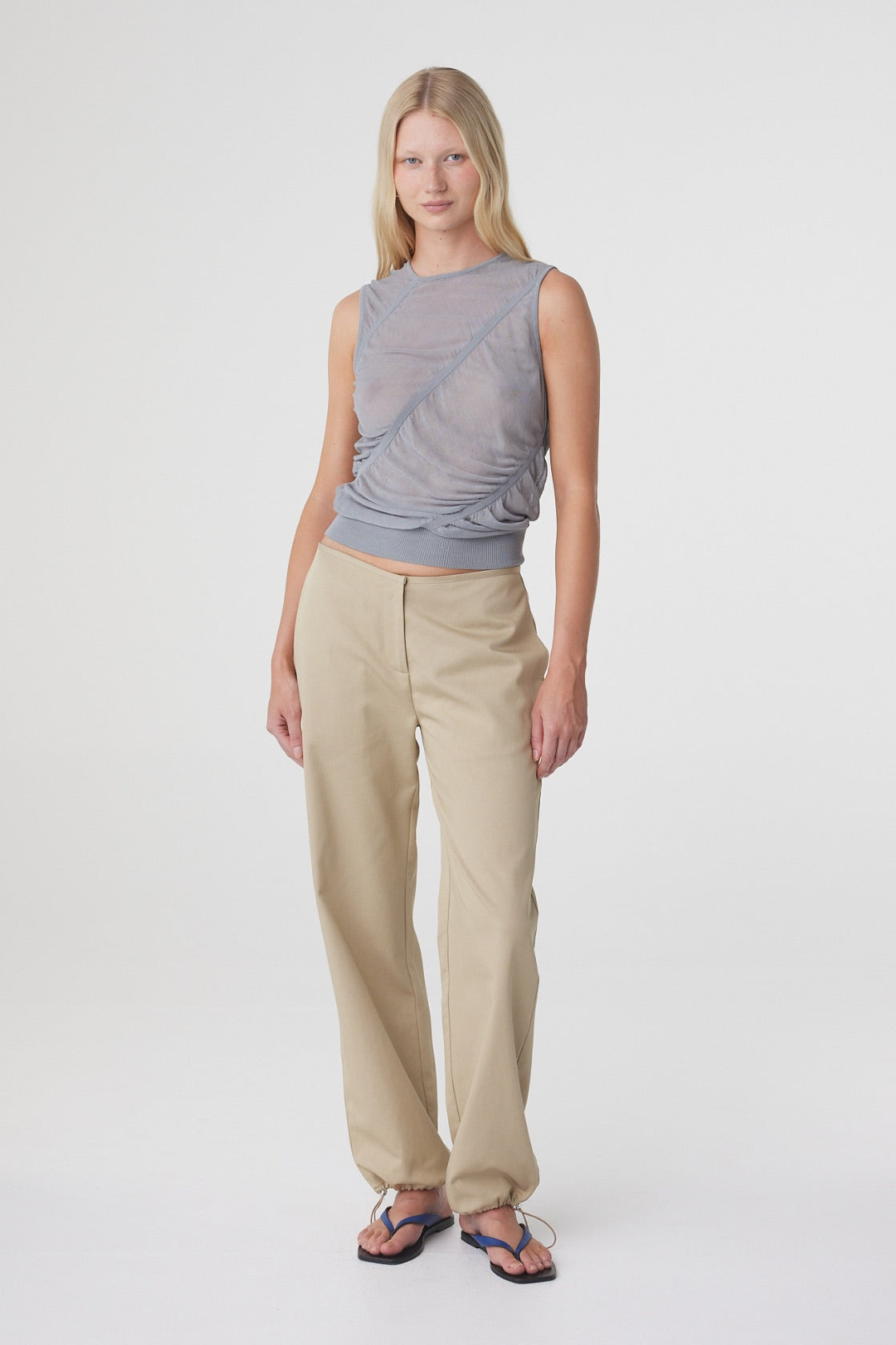 Hana Top in Mist, full length front view styled with cream trousers, showing the slim fit and ribbed hem sitting at the waist.
