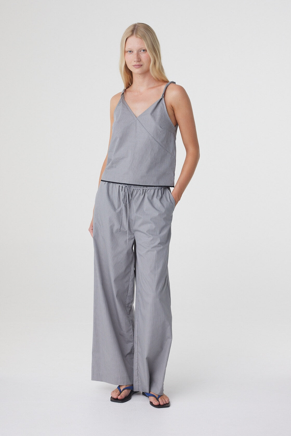 Sia Pant in Muted Blue Check styled with the matching top, three quarter front view with hand in the side seam pocket.