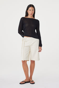 Full-length styled view of the Lucia Tie Bermuda Short in Bone featuring the double tie waist and relaxed Bermuda shape, paired with a black long sleeve top.