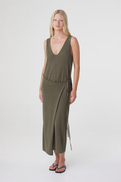 Sarina Wrap Maxi Dress in Smokey Olive, angled front view showing the asymmetrical wrap and movement through the skirt.
