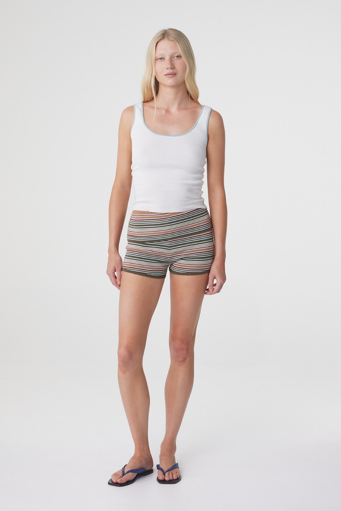Model wearing the Tove Short in Olive Stripe with a white tank, relaxed front three quarter view.