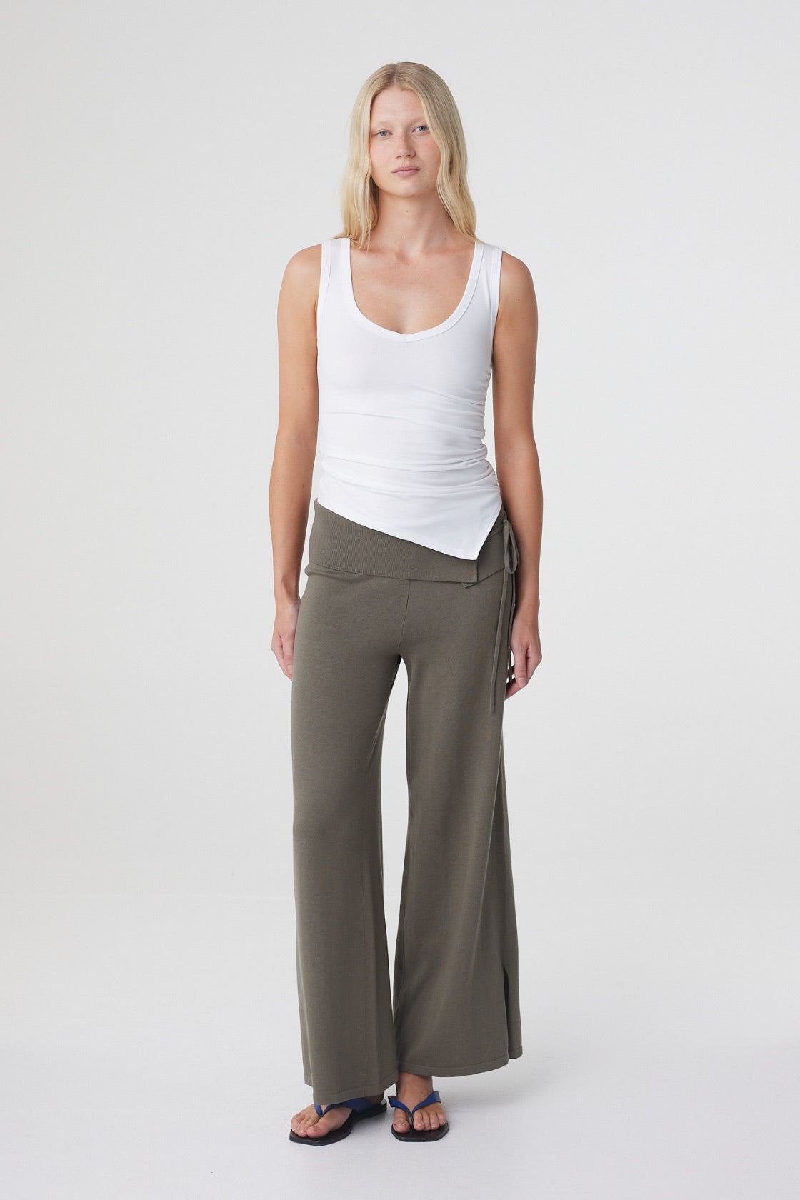 Elin Tank in Cream, relaxed three quarter front view highlighting the asymmetrical hem and fitted stretch cotton silhouette.