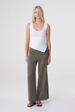 Elin Tank in Cream, relaxed three quarter front view highlighting the asymmetrical hem and fitted stretch cotton silhouette.