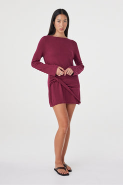 Angled front view of the Kira Mini Dress in Merlot showcasing the twisted wrap detail, soft drape and relaxed long sleeve silhouette.