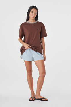 Kylen Tee in Espresso & Cream styled with pale blue shorts, full-length front view showing the relaxed oversized fit and longer length.