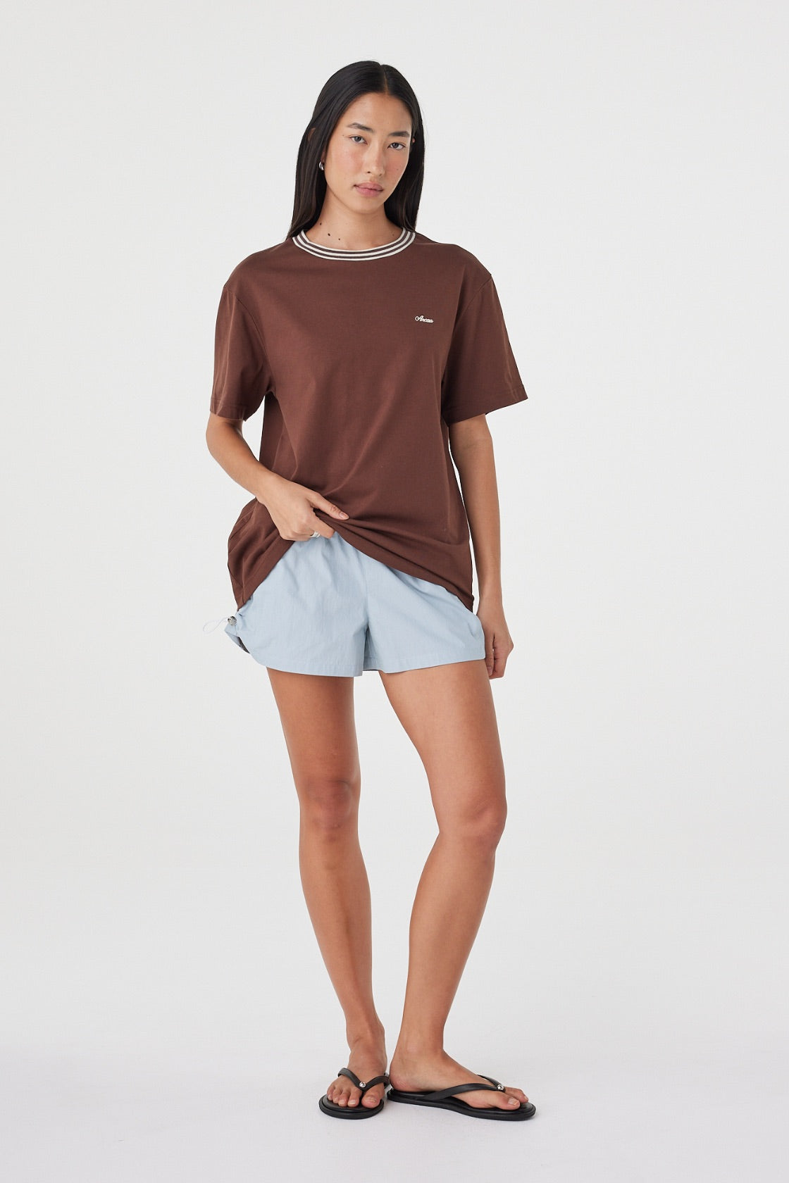 Kylen Tee in Espresso & Cream styled with pale blue shorts, full-length front view showing the relaxed oversized fit and longer length.