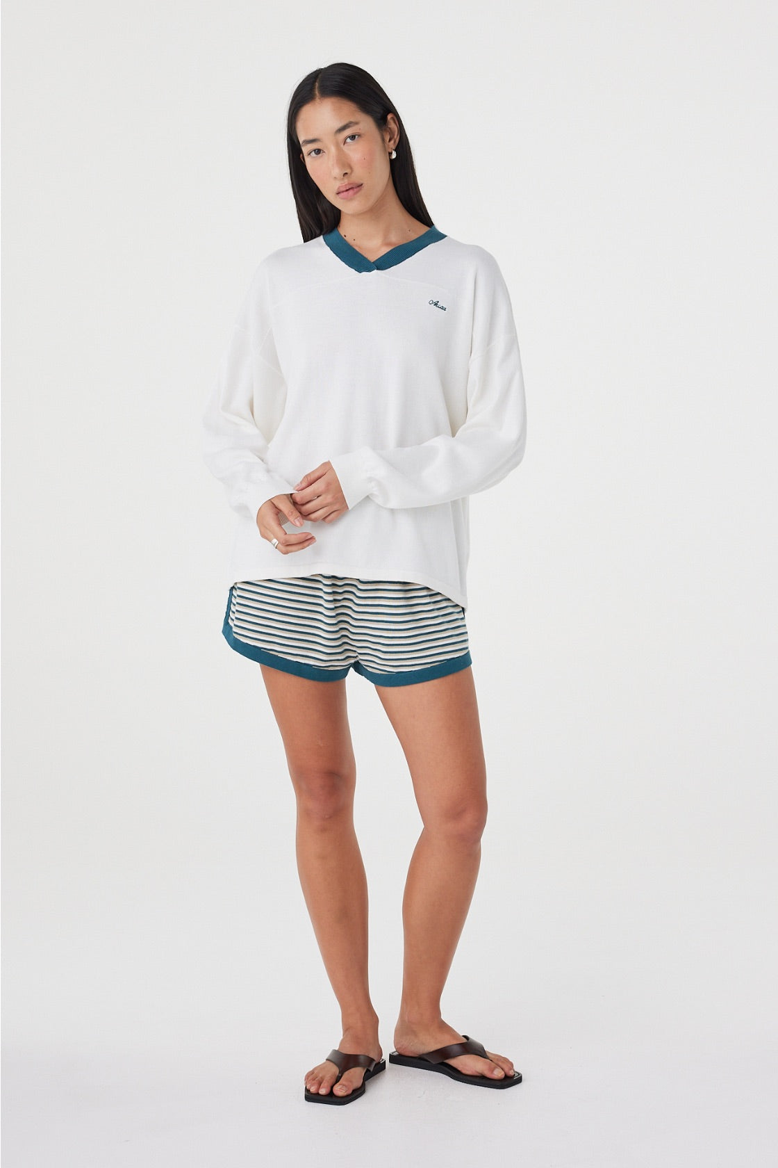 Full-length front view of the Cammy LS Tee in Cream & Teal showcasing the slouchy oversized fit, long sleeves and contrast teal neckline, paired with striped shorts.