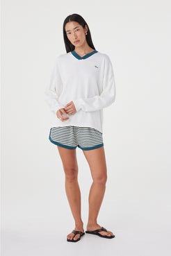 Full-length front view of the Cammy LS Tee in Cream & Teal showcasing the slouchy oversized fit, long sleeves and contrast teal neckline, paired with striped shorts.