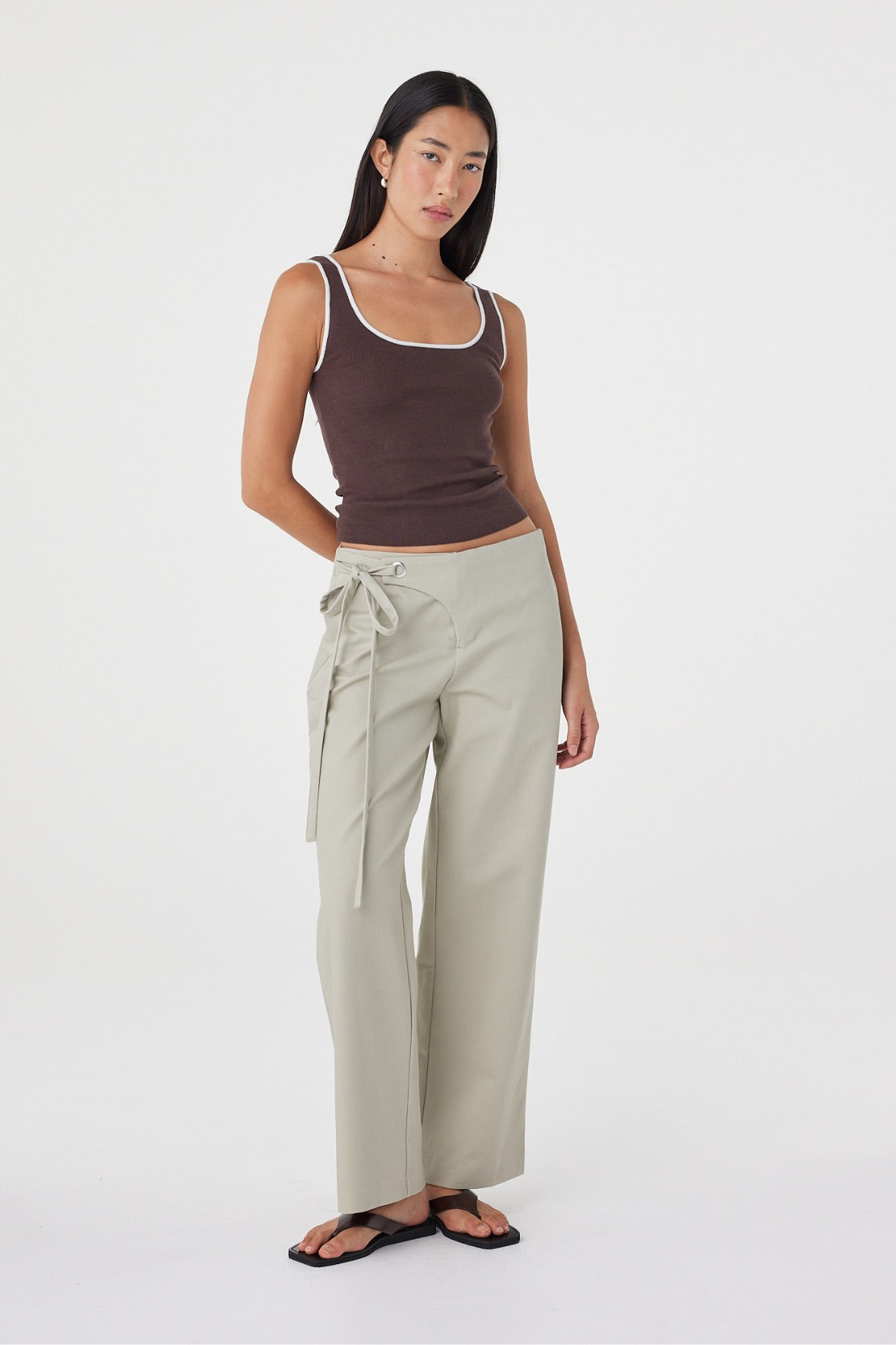 Full-length front view of the Kaya Tank in Espresso & Cream showcasing the fitted shape, contrast neckline and lightweight knitted construction, paired with light sage wrap pants.