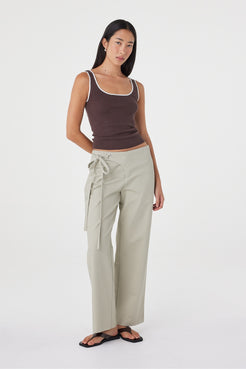 Full-length front view of the Kaya Tank in Espresso & Cream showcasing the fitted shape, contrast neckline and lightweight knitted construction, paired with light sage wrap pants.