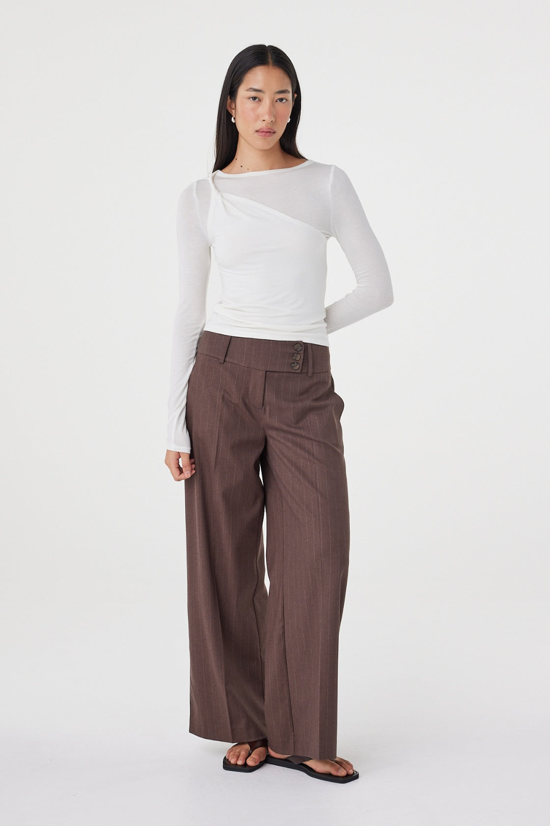 Full-length front view of the Mabel LS Twist Top in Cream showcasing the fitted silhouette, long sleeves and front shoulder twist detail, paired with the Manon Pant in Espresso Pinstripe.