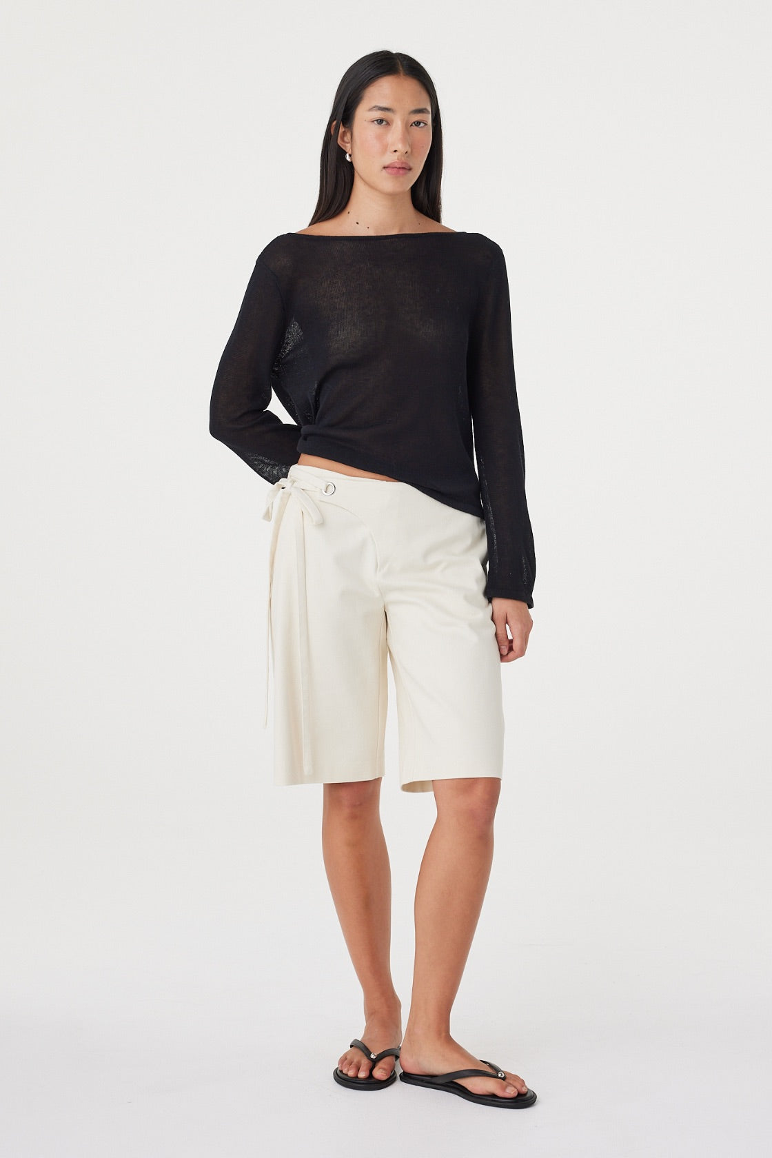 Full-length front view of the Nia LS Top in Black styled with bone Bermuda shorts, showing the relaxed fit and long sleeves.