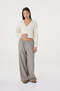 Angled full-length view of the Liora Fluffy Cardigan in cream highlighting the soft fluffy knit texture, ribbed sleeve cuffs and relaxed everyday styling