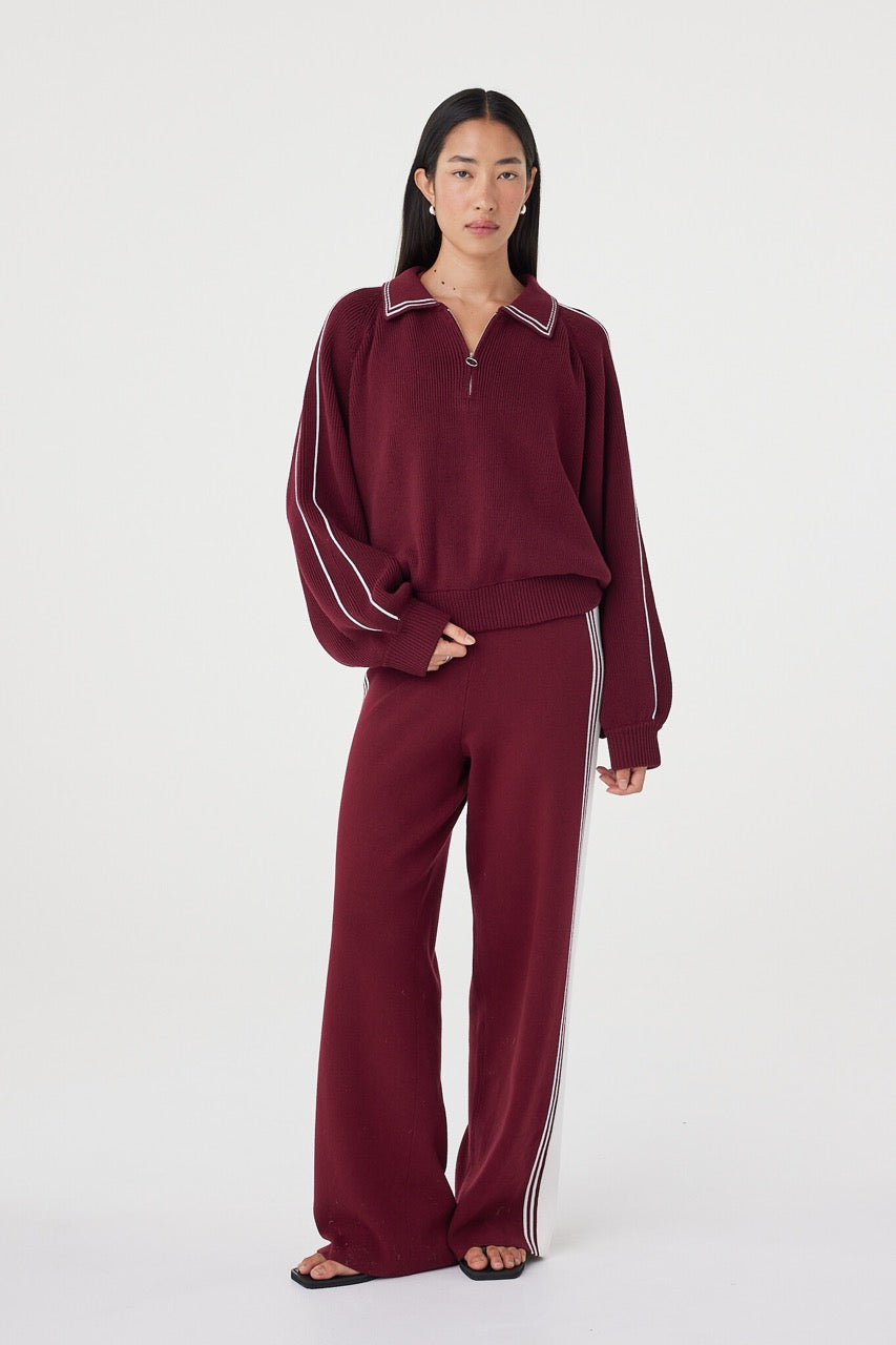 Angled front view of the Nella Zip in merlot and cream highlighting the drape through the body, contrast piping detail and relaxed sporty styling