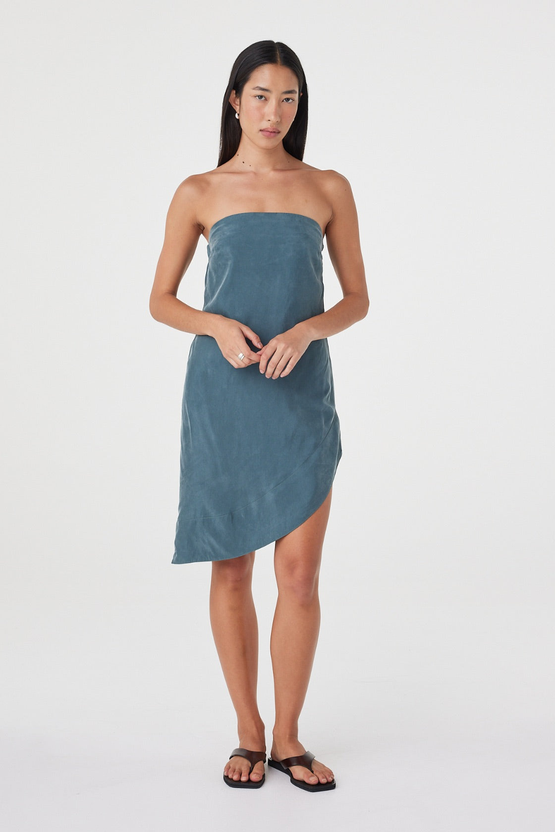 Front styled view of the Rhea Dress in Teal worn on its own, showing the soft drape and asymmetrical length.