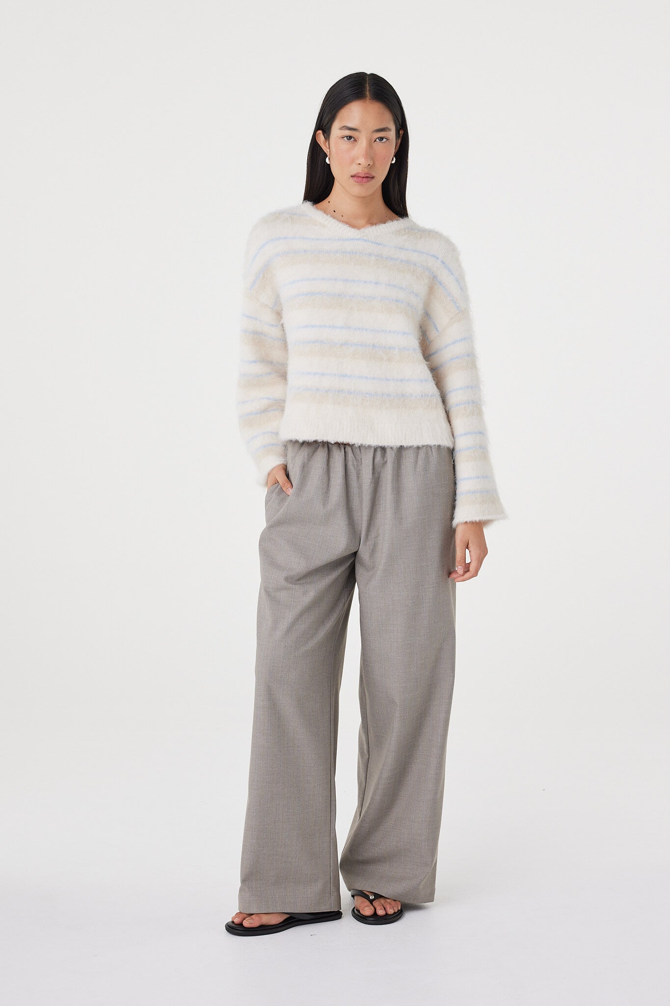 Angled front view of the Lucca Sweater in taupe and blue stripe highlighting the soft fluffy texture, relaxed V-neckline and effortless layered styling with neutral separates