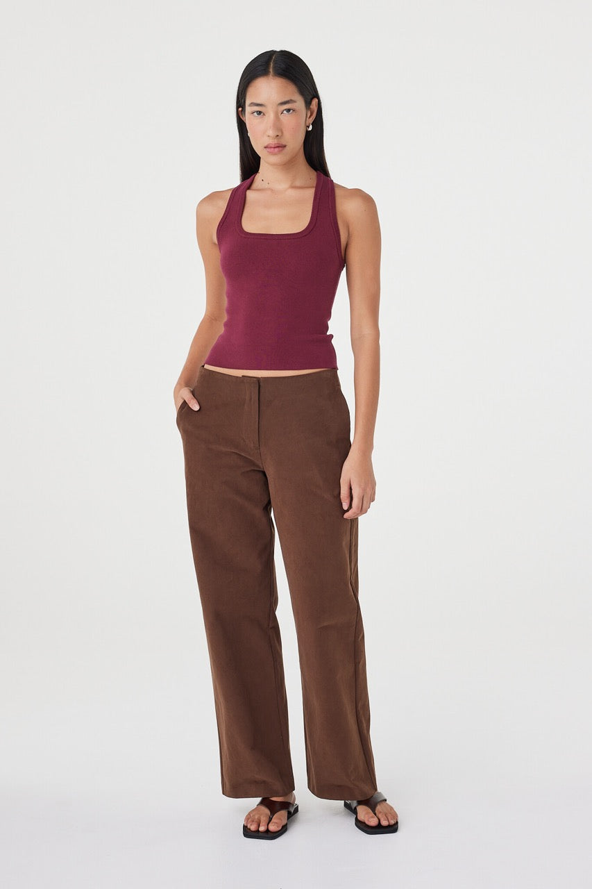 Relaxed front-facing view of the Sable Top in merlot paired with espresso tailored pants, showcasing the racerback cut, slim fit and clean everyday styling
