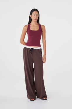 Angled front view of the Tully Pant in espresso with contrast cream side stripes and waistband, styled casually with a fitted sleeveless knit top and minimal black sandals