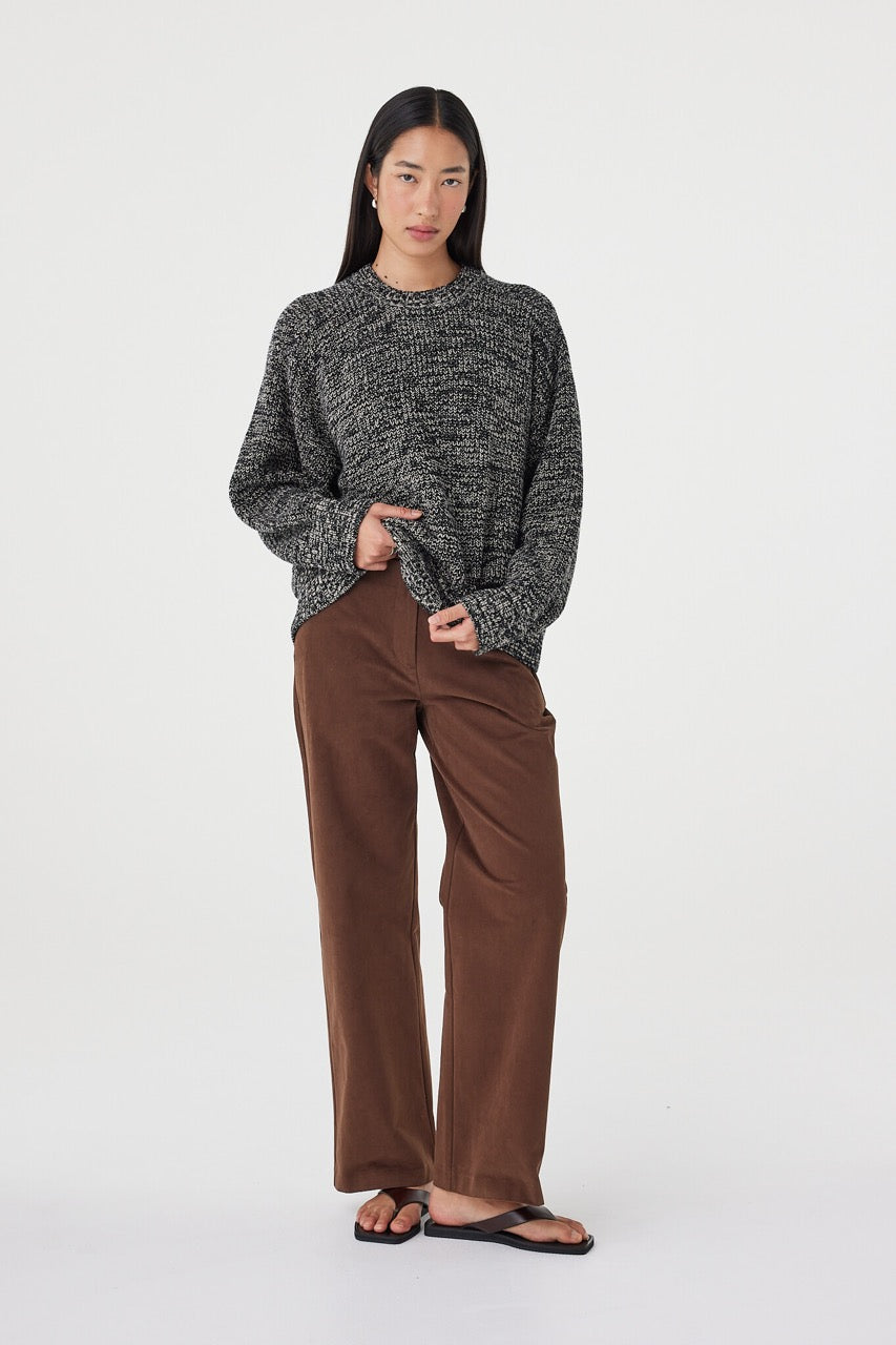 Relaxed front-facing view of the Solene Sweater in black and taupe featuring ribbed cuffs, chunky cotton knit texture and an easy oversized silhouette 