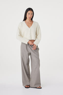 Relaxed front-facing view of the Liora Fluffy Cardigan in cream worn with taupe pants and black sandals, featuring dropped shoulders and a soft cropped silhouette