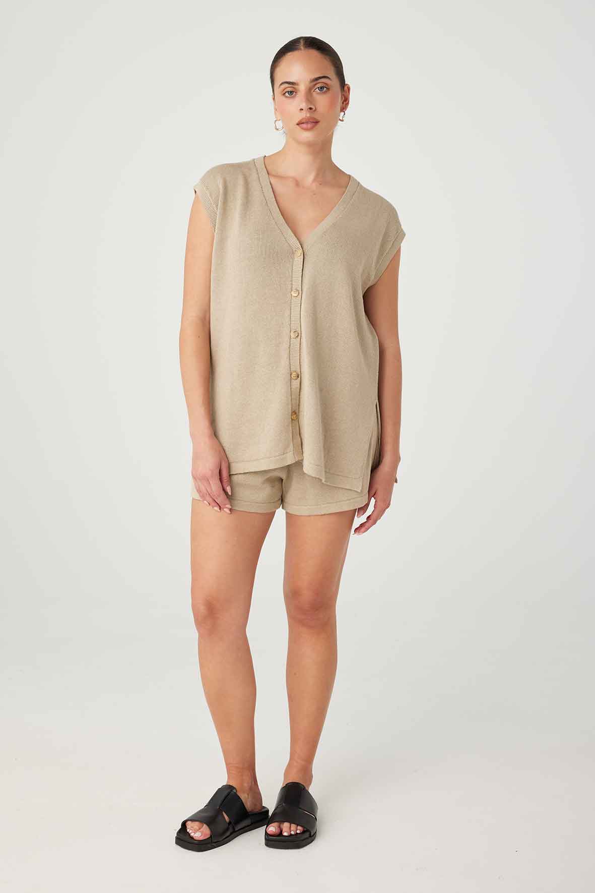 Full-body shot of Ada Vest in taupe, featuring button-down front, V-neck, and side splits, in a relaxed fit with sustainable materials.