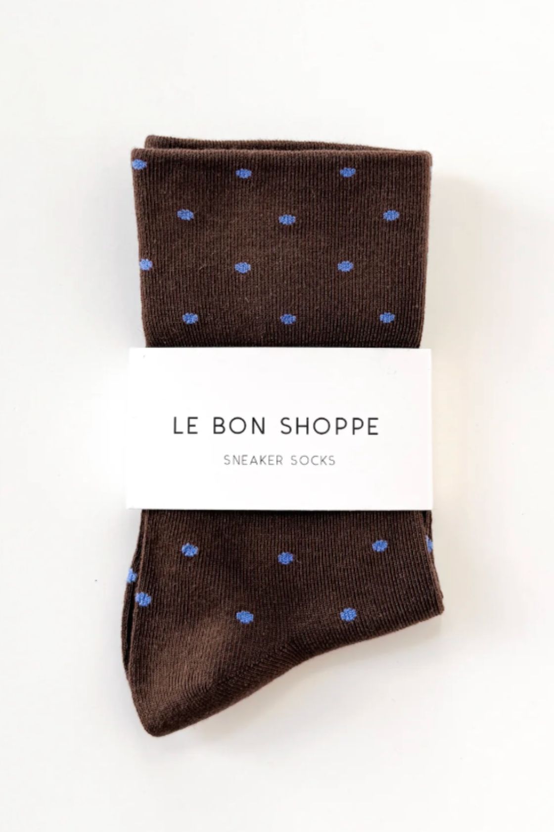 Brown socks with blue polka dot pattern folded with Le Bon Shoppe label