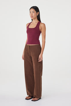 Side view of the Avery Pant in espresso featuring the velvet-finish cotton texture, relaxed straight-leg fit and clean waist construction, styled with a fitted sleeveless top