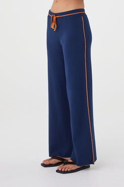 Side view of the Milan Pant in Navy & Tumeric highlighting the contrast stripe detailing and wide-leg silhouette.
