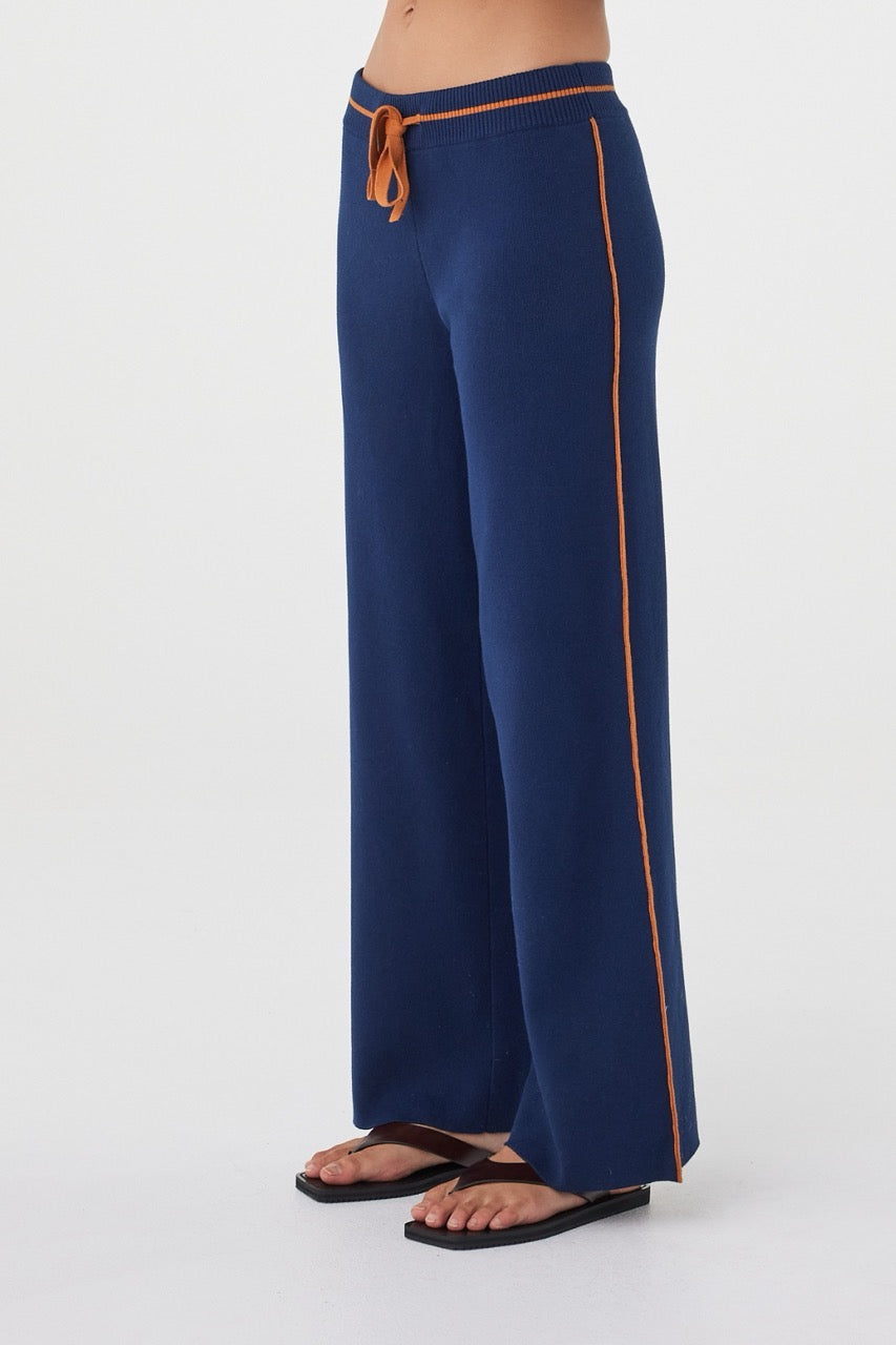 Side view of the Milan Pant in Navy & Tumeric highlighting the contrast stripe detailing and wide-leg silhouette.
