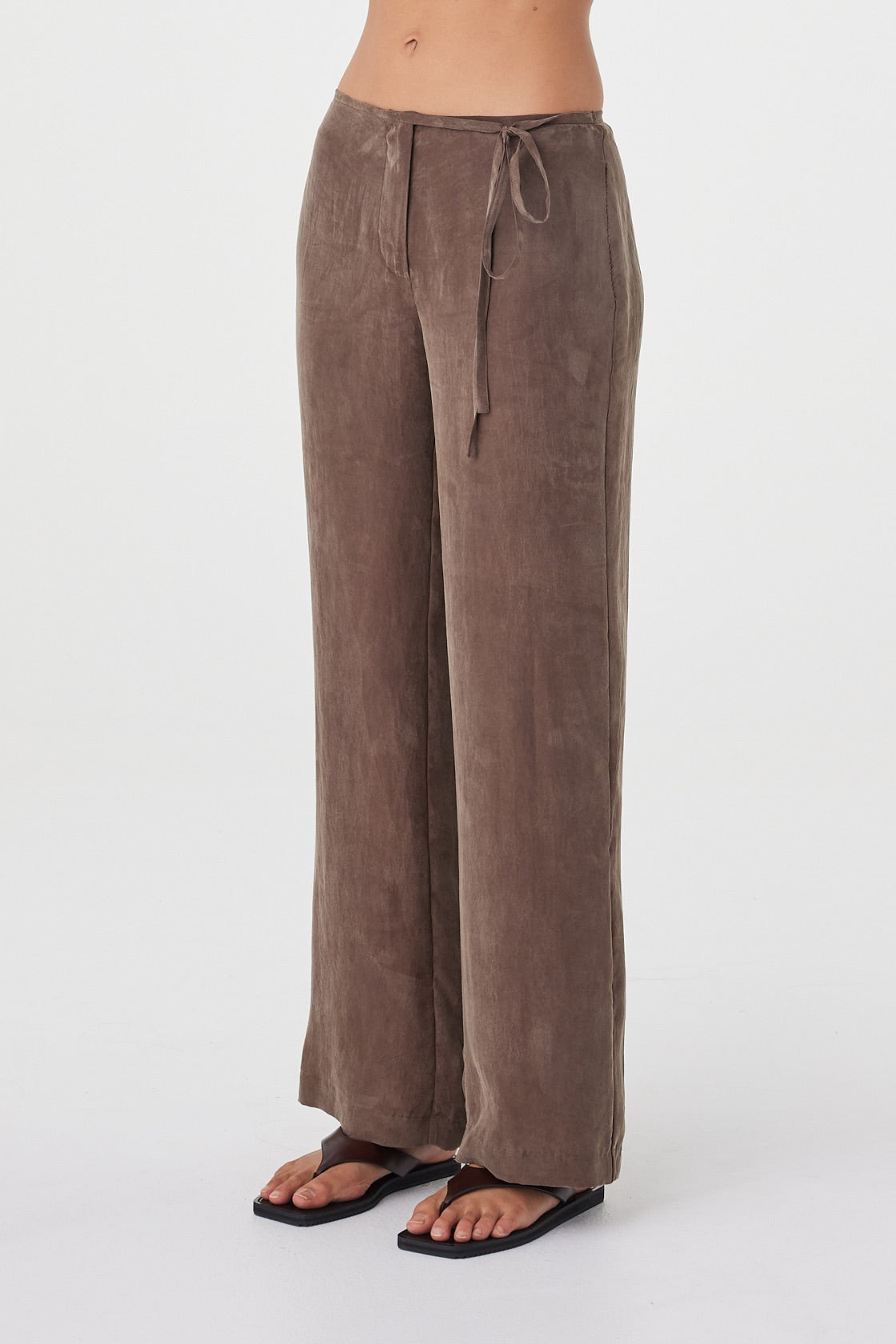 Angled view of the Maisie Tie Pant in Espresso highlighting the mid-rise waist, subtle side tie detail and fluid cupro blend fabrication.