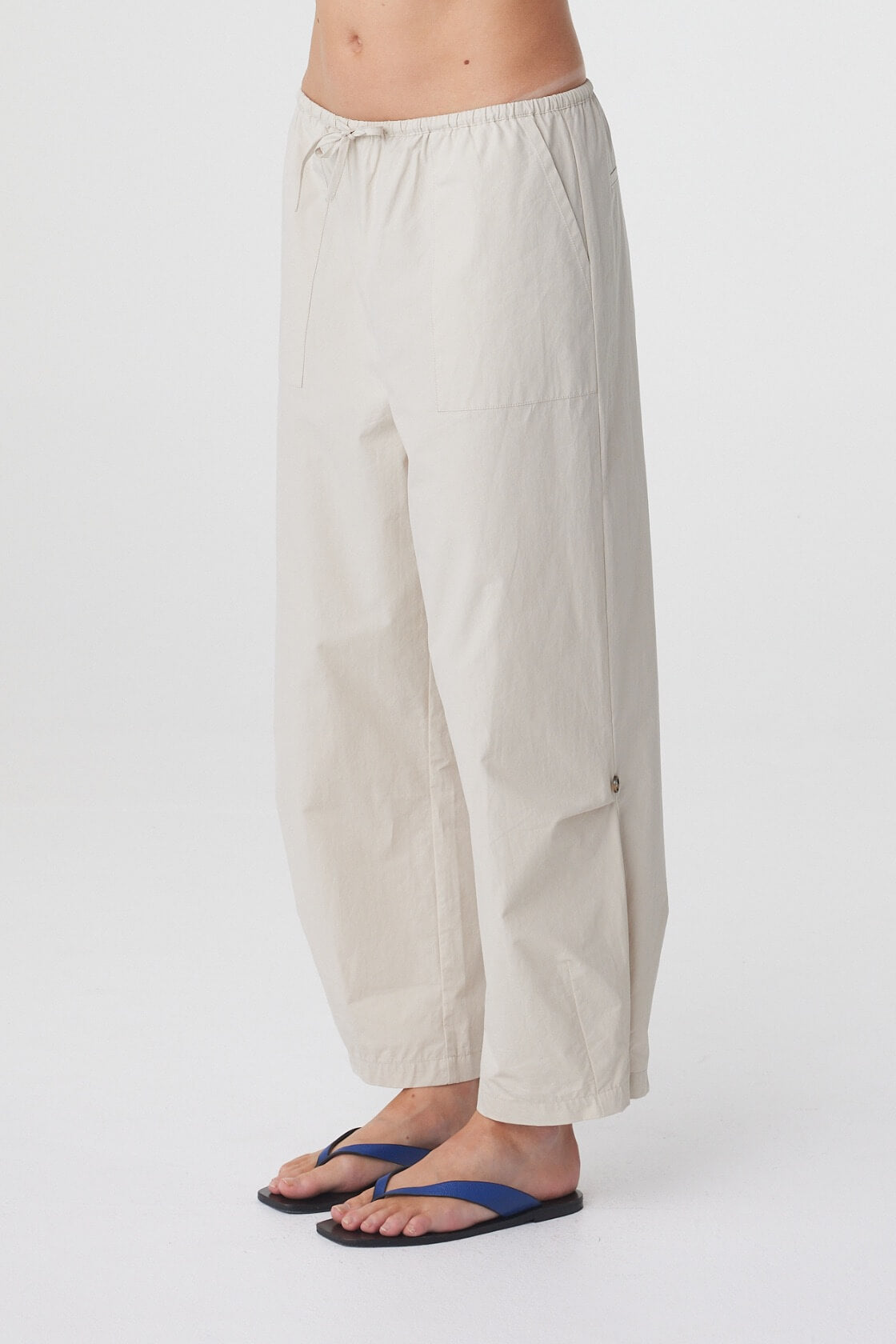 Lena Barrel Pant in Taupe, close side view highlighting the patch pocket and curved shape through the leg.