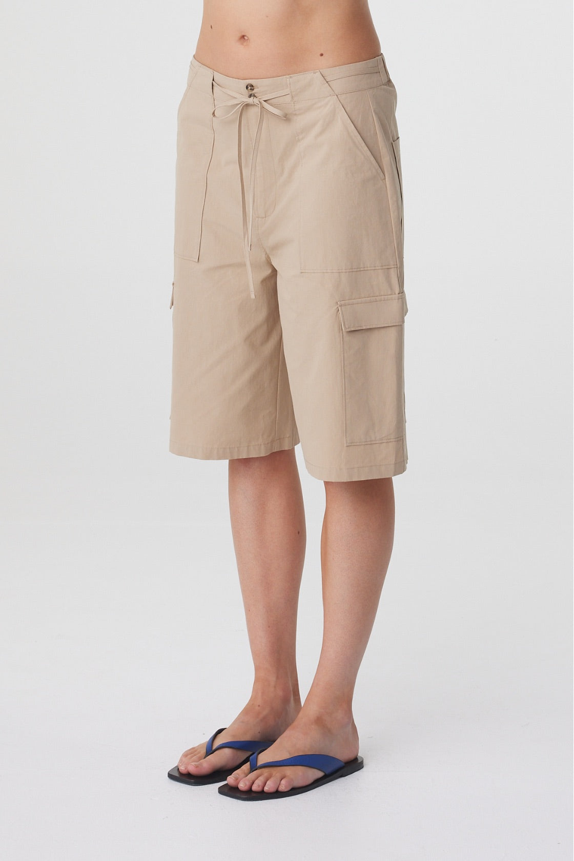 Daria Short in Camel, close three quarter view highlighting the cargo pocket detailing and knee length shape.