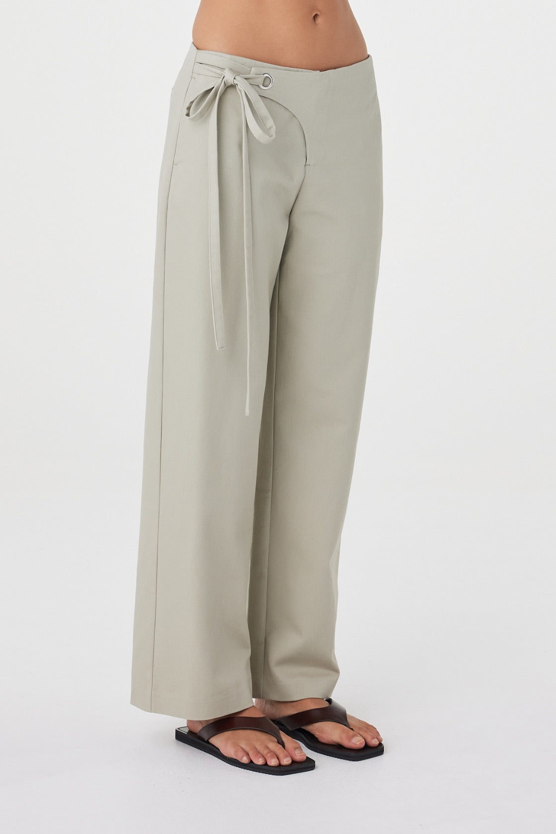 Side detail view of the Lucia Tie Pant in Light Sage showcasing the adjustable double ties, soft cotton tencel fabrication and straight-leg profile.