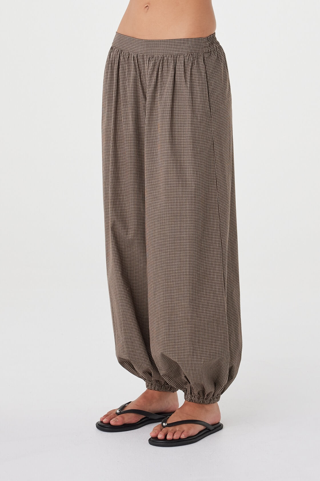 Angled close-up of the Elina Balloon Pant in Chocolate Check showcasing the balloon-leg shape, gathered ankle detail and soft cotton fabrication.