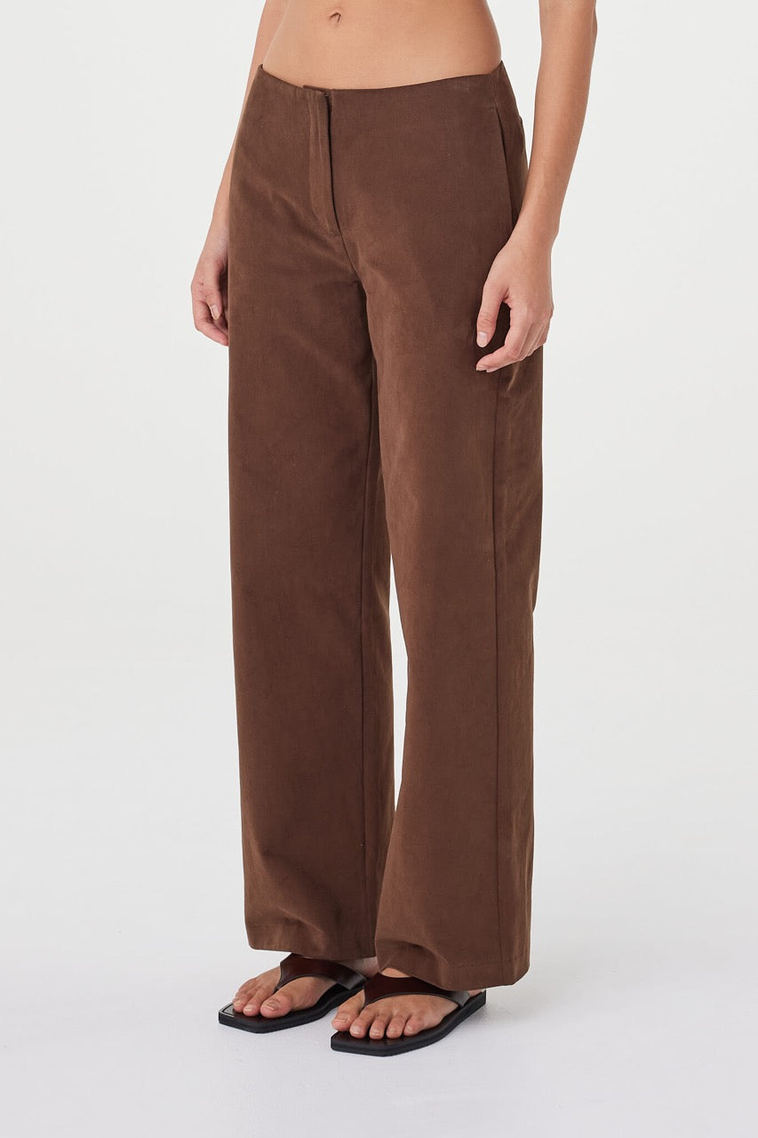 Angled close-up of the Avery Pant in espresso showing the soft matte velvet texture, straight-leg silhouette and fluid fall through the hem, styled with minimal sandals