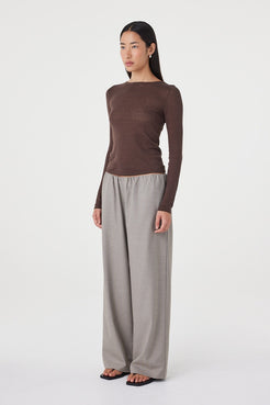 Full-length angled view of the Annika Pant in taupe blue pinstripe styled with a fitted chocolate brown knit top and black sandals for an elevated everyday loo
