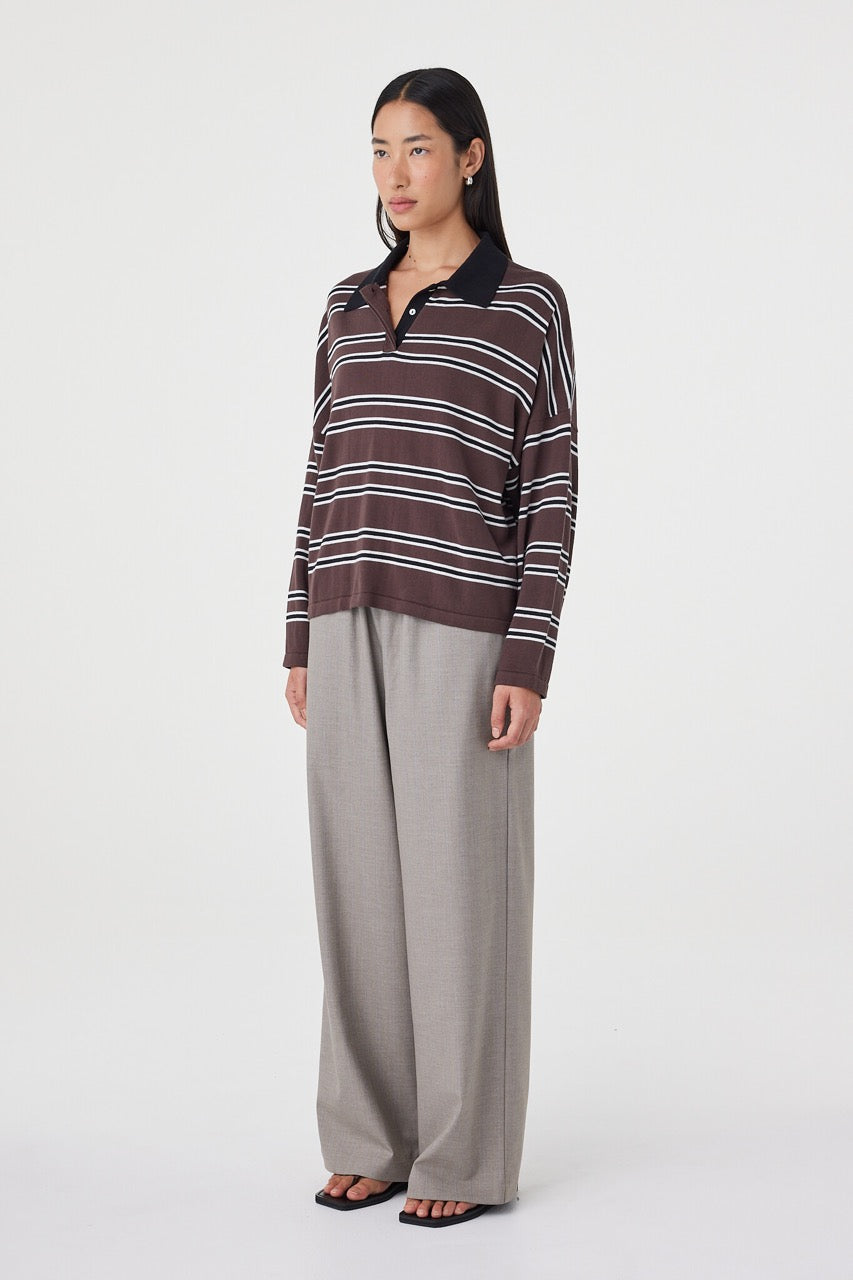 Side profile view of the Rayne Knit in espresso, black and cream paired with wide-leg taupe pants and black sandals, highlighting the drape through the body and dropped shoulder fit