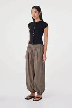Side view of the Elina Balloon Pant in Chocolate Check highlighting the soft balloon silhouette, gathered hem and relaxed drape, paired with the Robbie Top in Black.