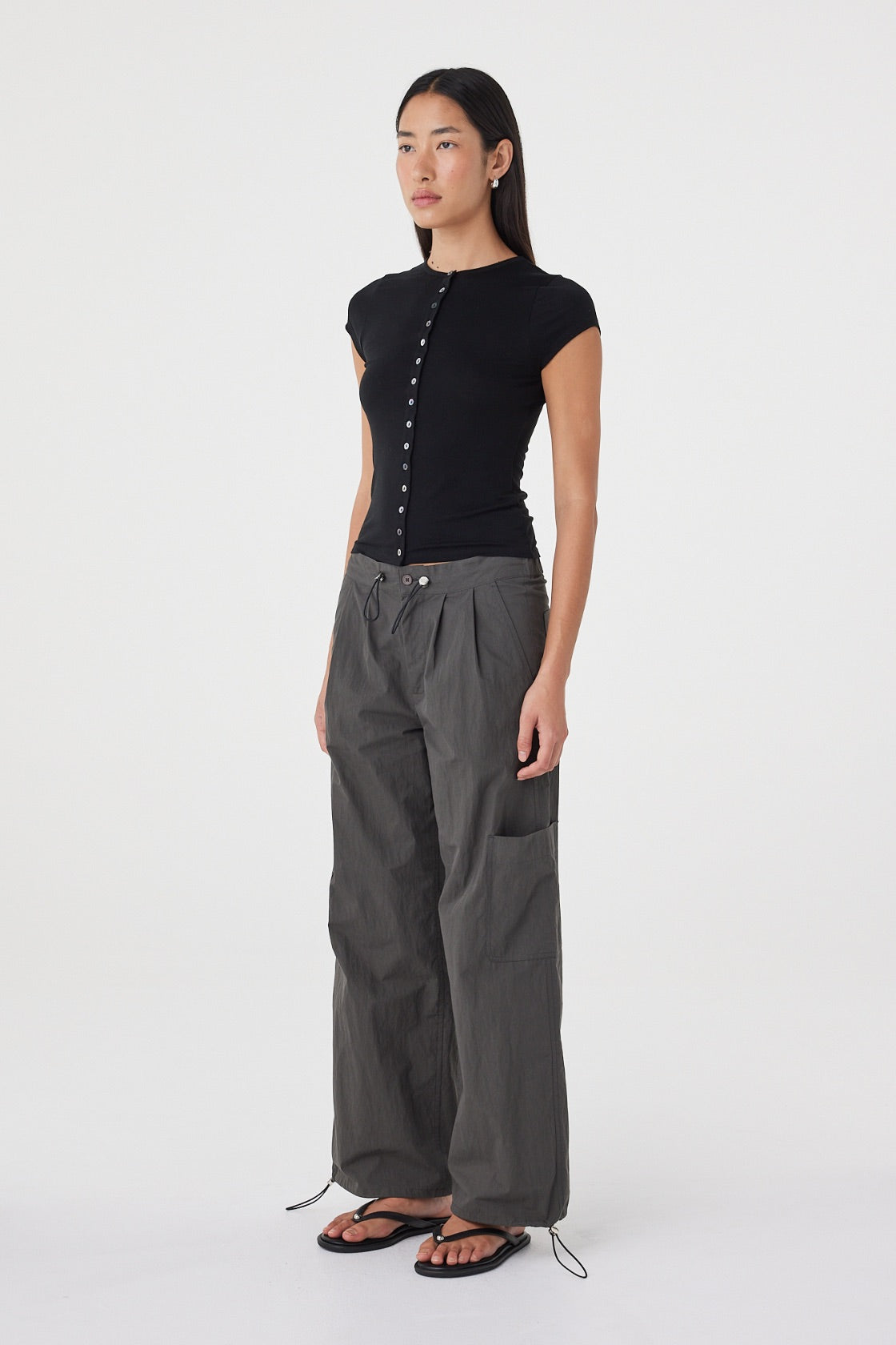Side view of the Robbie Top in Black featuring the slim profile, cap sleeves and lightweight knit construction.